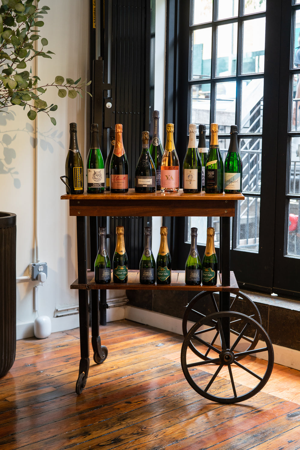 Bottles of sparkling wine on a bar cart by the shop window